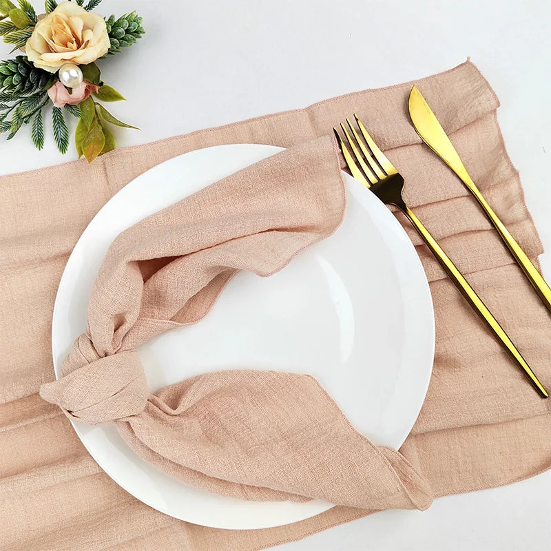 Une table élégante avec des couverts dorés, des serviettes en lin beige et des fleurs décoratives.