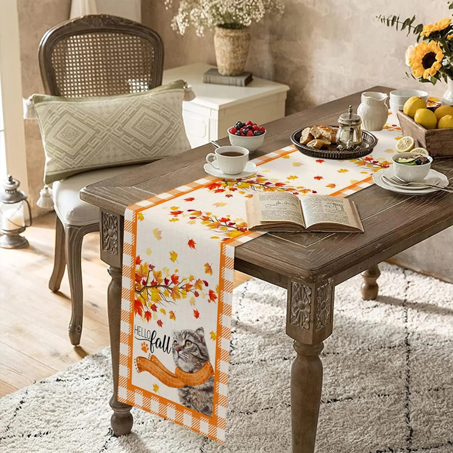 Une scène d'automne confortable avec une table en bois rustique, un livre ouvert, des fruits et des fleurs, ainsi qu'un chemin de table décoré de feuilles d'automne.