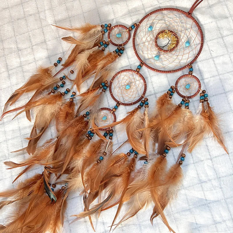 Rêveurs suspendus aux murs, ces capteurs de rêves ornés de plumes dorées et de perles aux teintes turquoise apportent une touche chaleureuse et mystique à l'espace.