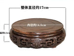 support circulaire bois sculpté artisanal traditionnel marron foncé détails complexes vase plantes décoration maison