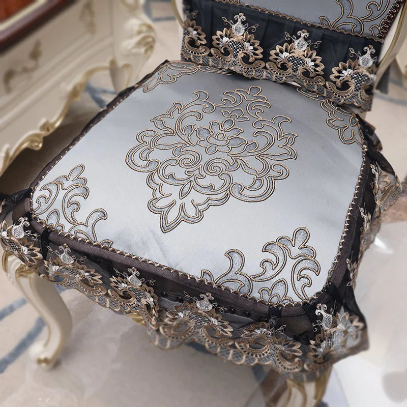 Gros plan sur un coussin décoratif noir et or avec un motif floral élégant, créant une atmosphère luxueuse et raffinée.