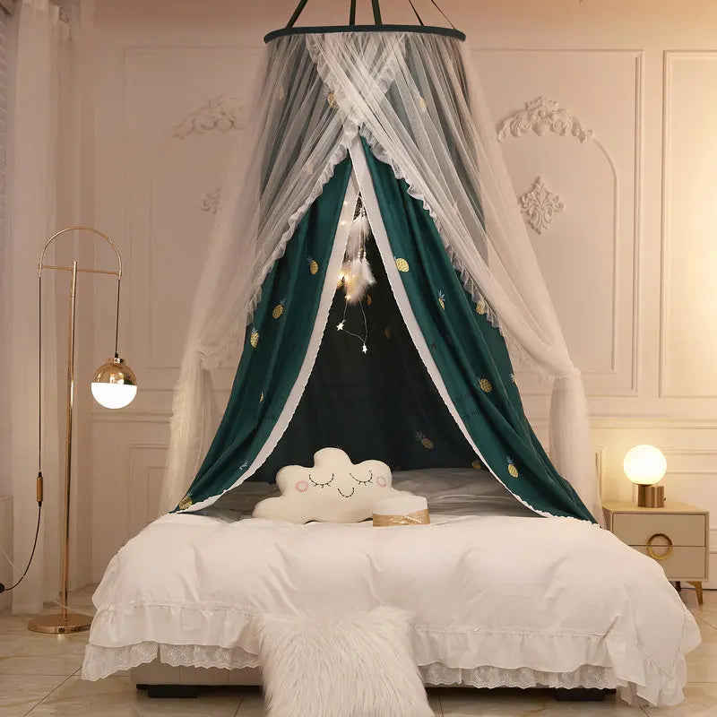 Une belle chambre à coucher avec un ciel de lit décoratif en tissu blanc et vert, rehaussé de motifs étoilés dorés, créant une ambiance chaleureuse et élégante.