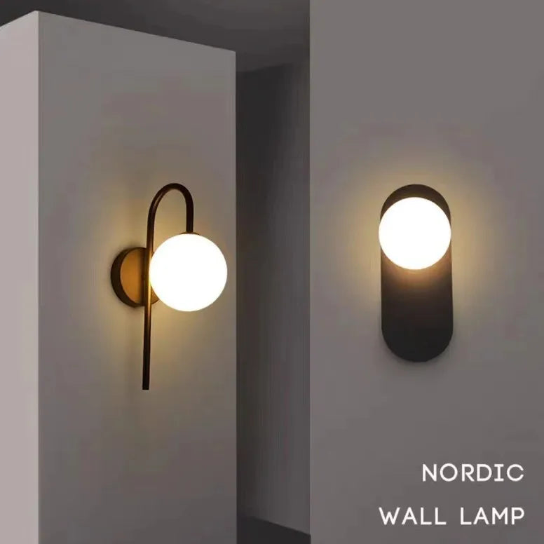 Applique murale dorée avec boule en verre laiteux sur mur blanc