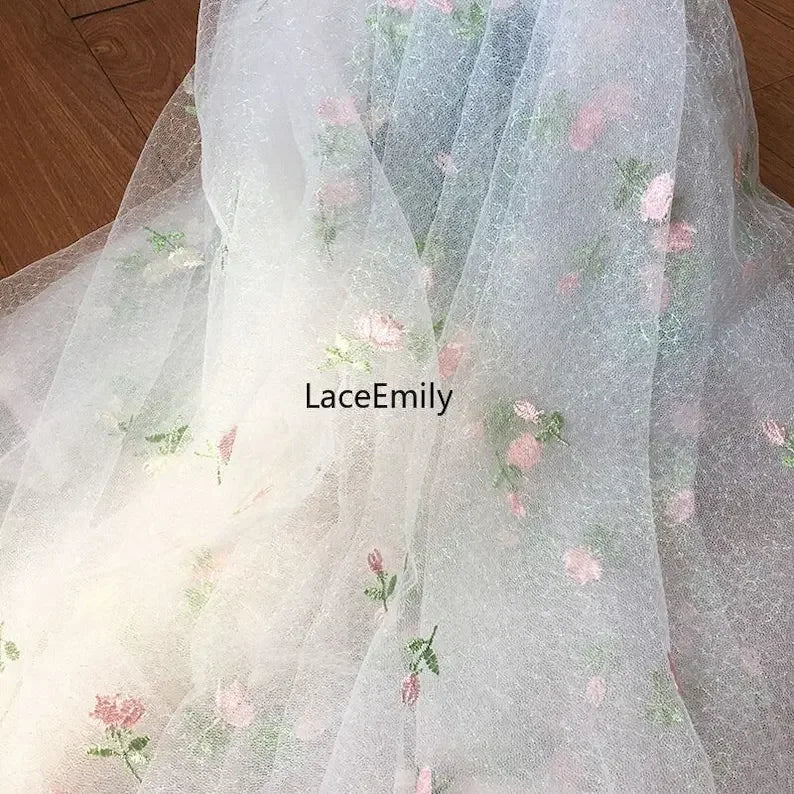 tissu dentelle transparent brodée motifs floraux roses feuilles romantique blanc rose vert