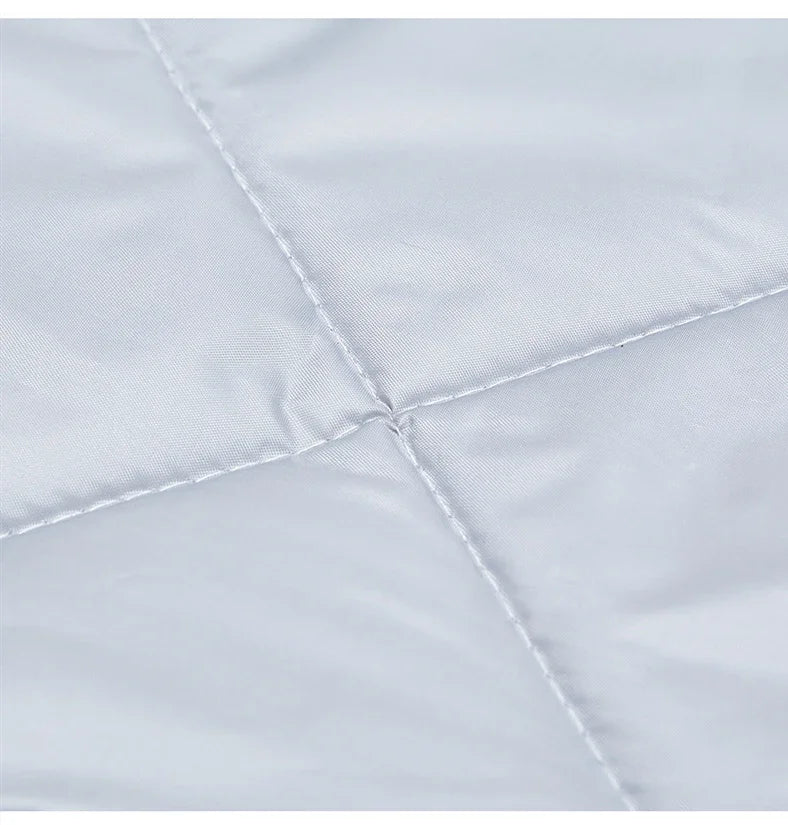 Gros plan du tissu matelassé gris clair du rideau de porte, montrant les coutures en losange et la texture douce et soyeuse.