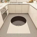 Motif géométrique noir et blanc saisissant sur un plancher de cuisine moderne avec un comptoir et des électroménagers dans un espace de cuisine épuré.