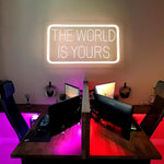 enseigne lumineuse néon carte monde THE WORLD IS YOURS bleu rose blanc fixations intérieur