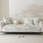 Un canapé confortable avec des coussins aux motifs rayés dans des tons beiges et gris, créant une atmosphère apaisante et sophistiquée.