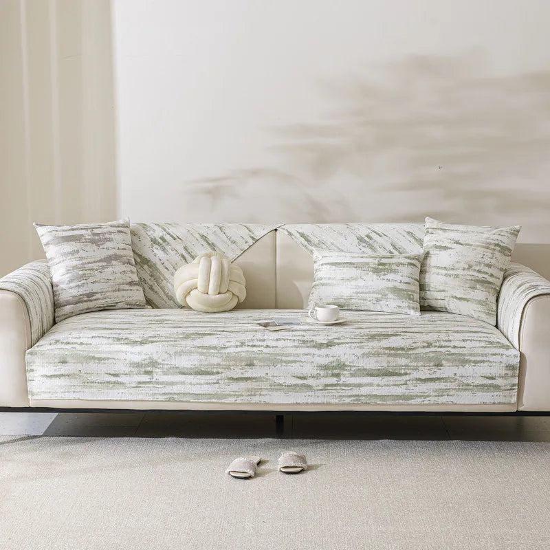 Un canapé confortable avec des coussins aux motifs rayés dans des tons beiges et gris, créant une atmosphère apaisante et sophistiquée.