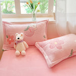 Un espace de détente confortable avec des coussins roses décorés de fleurs et d'un ours en peluche, créant une ambiance douce et chaleureuse.