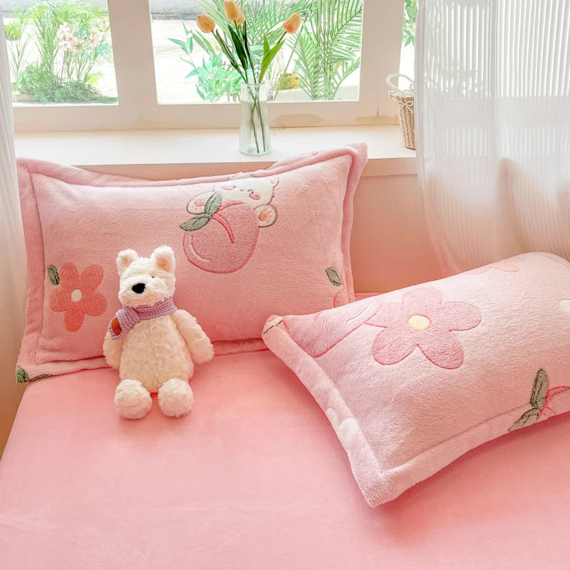 Un espace de détente confortable avec des coussins roses décorés de fleurs et d'un ours en peluche, créant une ambiance douce et chaleureuse.