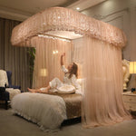 Un lit aux rideaux somptueux, avec une femme assise dessus dans un décor cosy et luxueux.