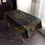Cette nappe noire et dorée, ornée de motifs astrologiques, crée une ambiance mystique et élégante dans la pièce.