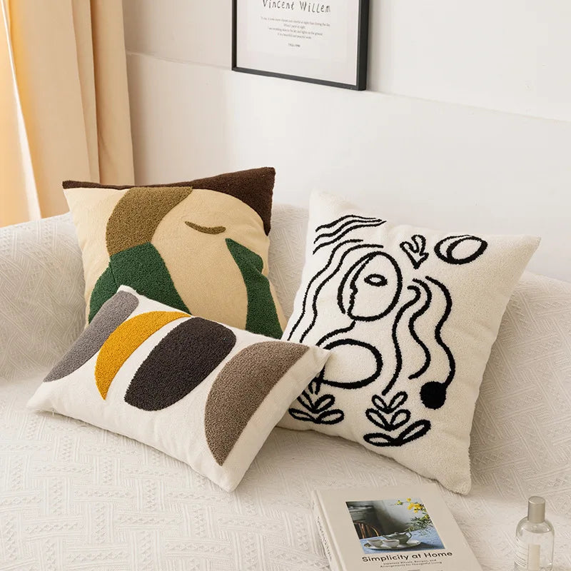 Deux oreillers décoratifs avec des motifs géométriques et abstraits, créant une atmosphère artistique et design dans la pièce.