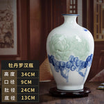 Vase blanc décoratif avec motifs floraux bleus sur fond sombre.