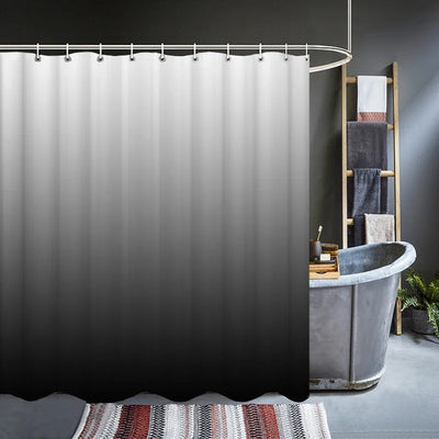 Rideau de douche présentant un dégradé du gris clair au noir, suspendu devant une baignoire de style industriel dans une salle de bain moderne.