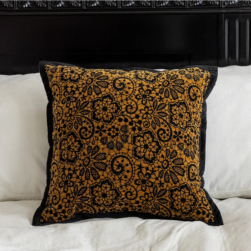 Coussin décoratif en tissu velours à motifs floraux dorés sur fond noir, qui apporte une touche d'élégance et de richesse dans un intérieur.