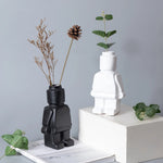 vase moderne figurine lego noir blanc vert fleurs eucalyptus branches cônes pins ludique décoration