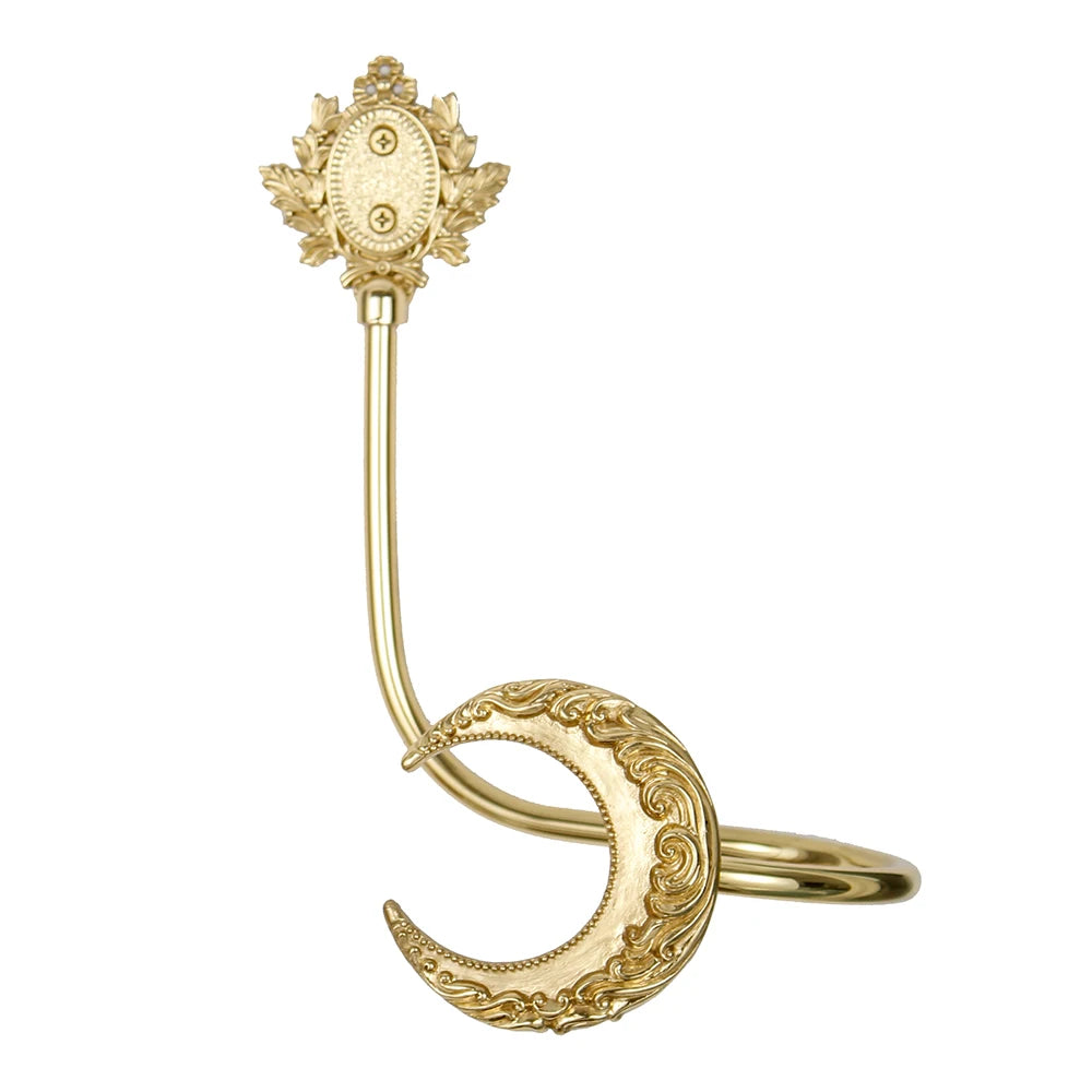 Bague de couleur or avec un pendentif décoratif orné de feuillage et de motifs ouvragés.