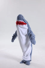 Un costume de requin en peluche grise avec des dents rouges menaçantes.