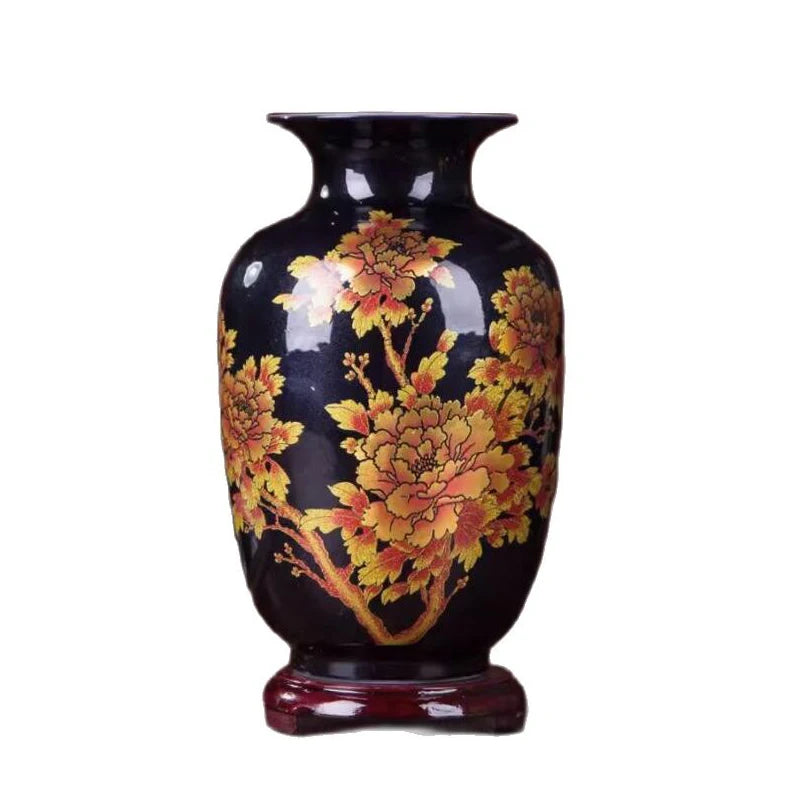 Un vase en céramique noire décoré de fleurs jaunes et orange épanouies.