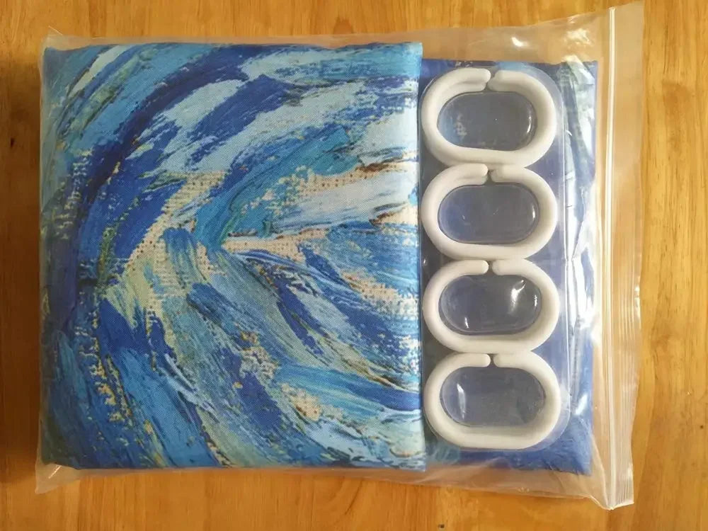 Le rideau plié, accompagné de ses anneaux de suspension blancs, présenté dans un emballage transparent. 