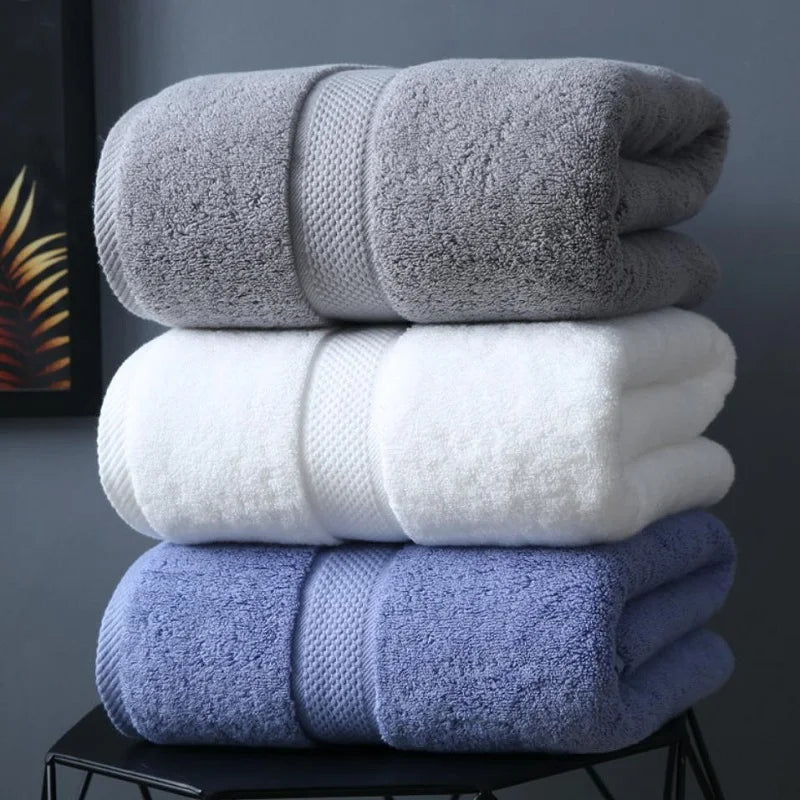 Serviette de bain en coton 800 GSM noir pliée sur un porte-serviettes en bois