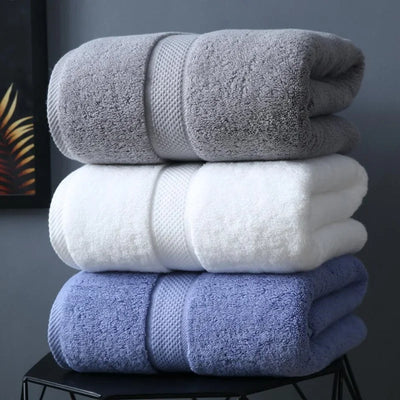 Serviette de bain en coton 800 GSM noir pliée sur un porte-serviettes en bois