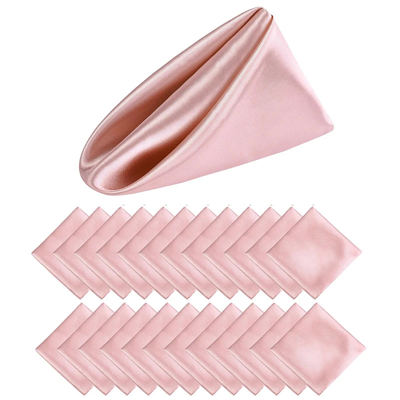 Un éventail de serviettes de table soyeuses de couleur rose pâle, pliées avec élégance pour compléter une table de fête raffinée.