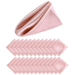 Un éventail de serviettes de table soyeuses de couleur rose pâle, pliées avec élégance pour compléter une table de fête raffinée.