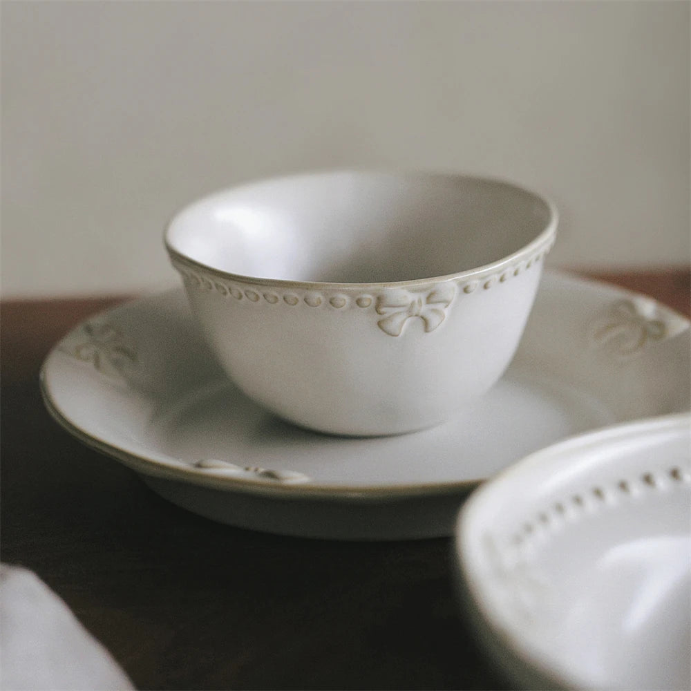 Un ensemble de bols en porcelaine blanche ornés de délicates décorations florales, suggérant une atmosphère de calme et d'élégance.