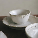 Un ensemble de bols en porcelaine blanche ornés de délicates décorations florales, suggérant une atmosphère de calme et d'élégance.