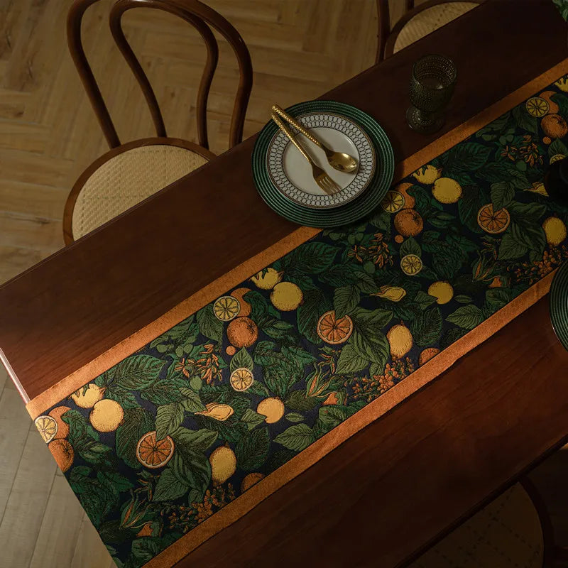 La table de salle à manger est décorée d'un beau chemin de table avec un motif floral et de fruits colorés, ajoutant une touche chaleureuse et élégante à l'espace.