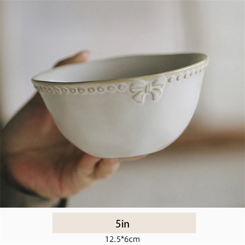 Bol blanc décoré d'un motif floral élégant, idéal pour la cuisine ou la décoration intérieure.