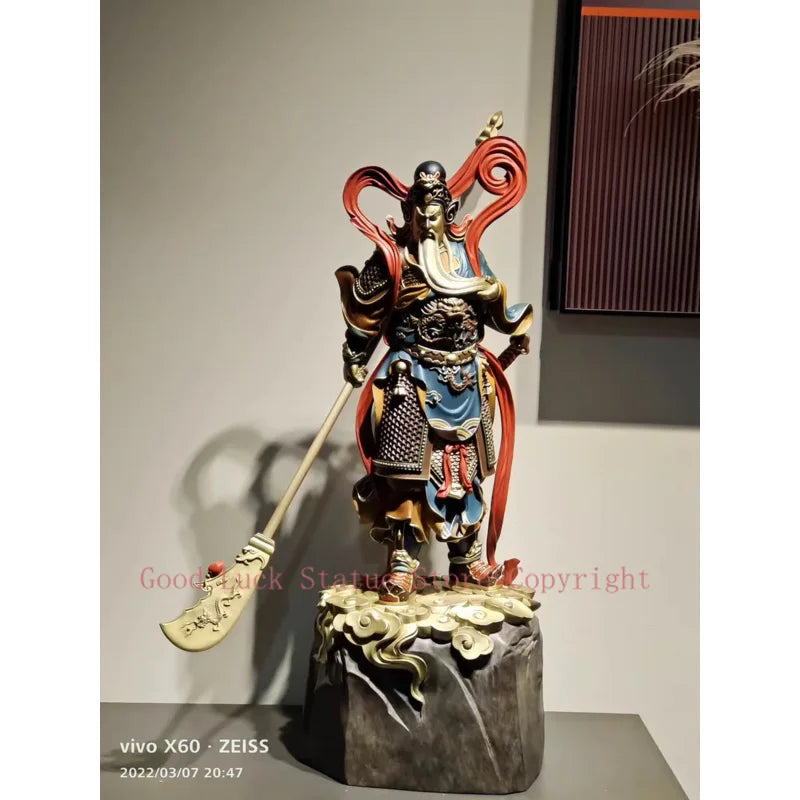 statue personnage masculin armure bâton socle rocheux motifs complexes couleurs or rouge bleuTextures variées