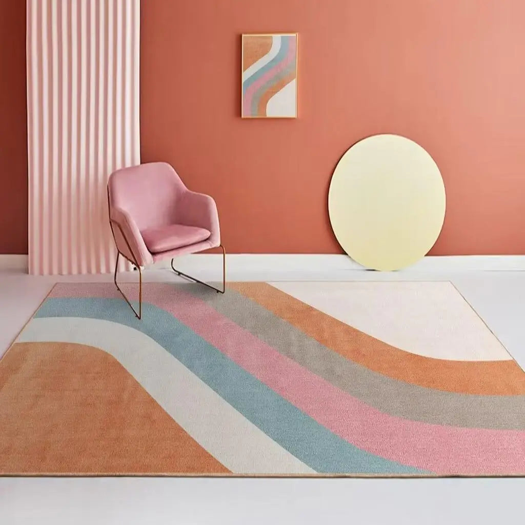 Un fauteuil rose posé sur un tapis aux motifs géométriques colorés, avec un cadre décoratif sur le mur et un miroir rond blanc, créant une ambiance lumineuse et épurée dans cette pièce.