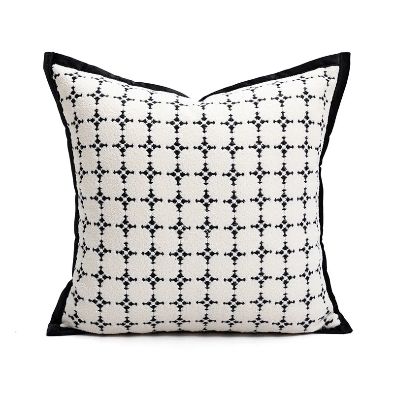 Coussin décoratif blanc et noir avec un motif géométrique répétitif, parfaitement adapté pour une décoration de style contemporain.