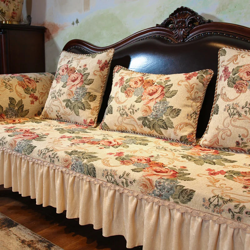 Ce canapé est orné d'un motif floral vintage sur un tissu beige, avec des coussins assortis et une finition en bois sculpté.