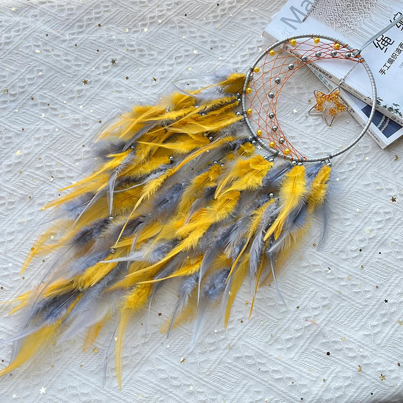 Captivant capteur de rêves aux plumes jaunes et grises, orné de perles et de fils scintillants, créant une œuvre d'art unique et fascinante.