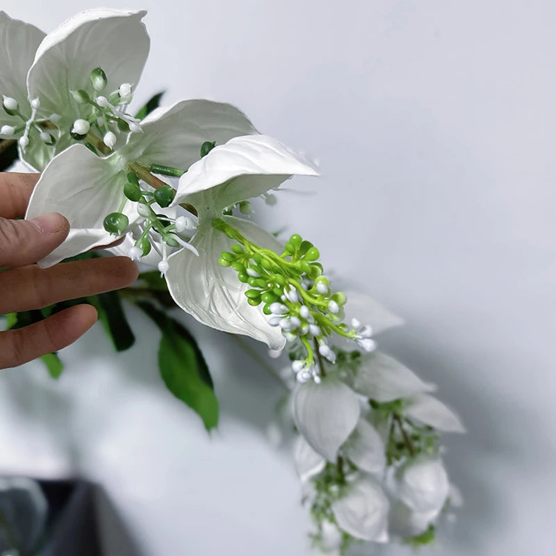 branche artificielle fleurs naturelles extérieur accrochées blanc vert feuilles larges minimaliste