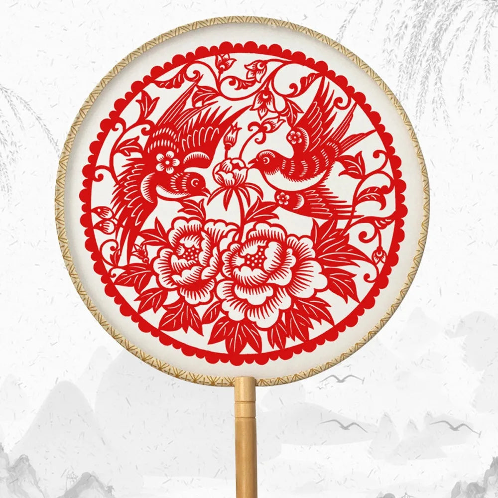 éventail artisanal traditionnel motifs floraux géométriques poignée bois pompon rouge soie tissée opacité festive