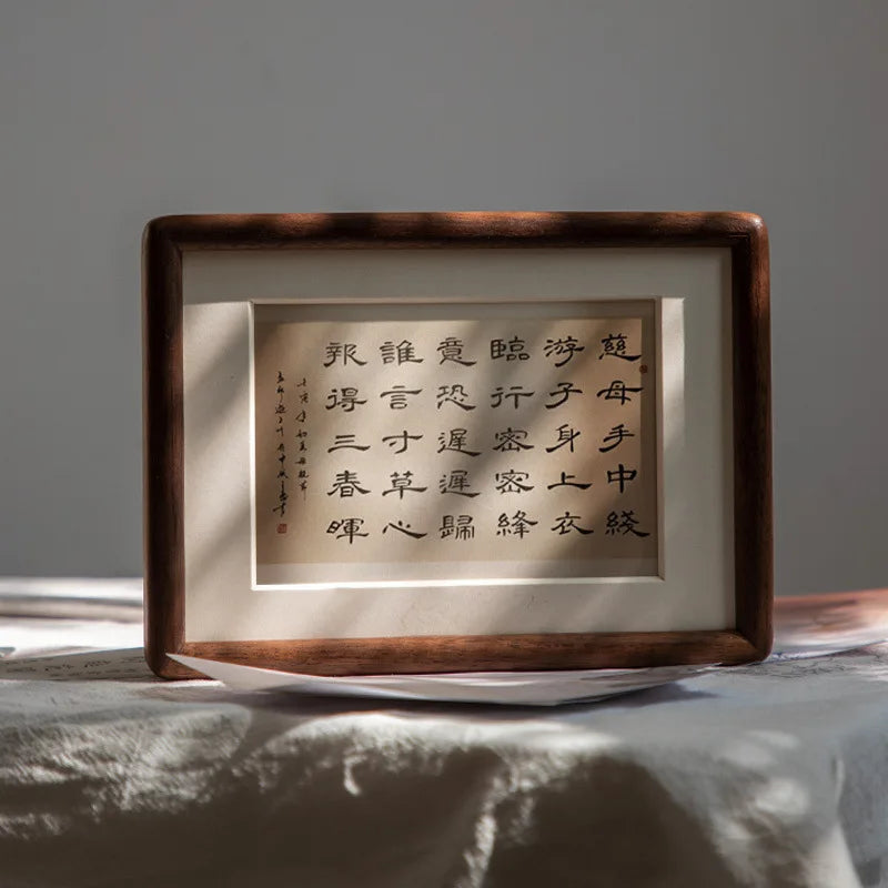 cadre photo bois marron foncé pouces dorés papier blanc mat calligraphie noire minimaliste decoration