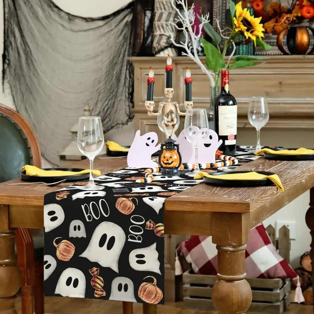 Sur une table de bois, un service de table d'halloween décoré avec des fantômes, une citrouille, des bougies, des verres à vin et une bouteille de vin.