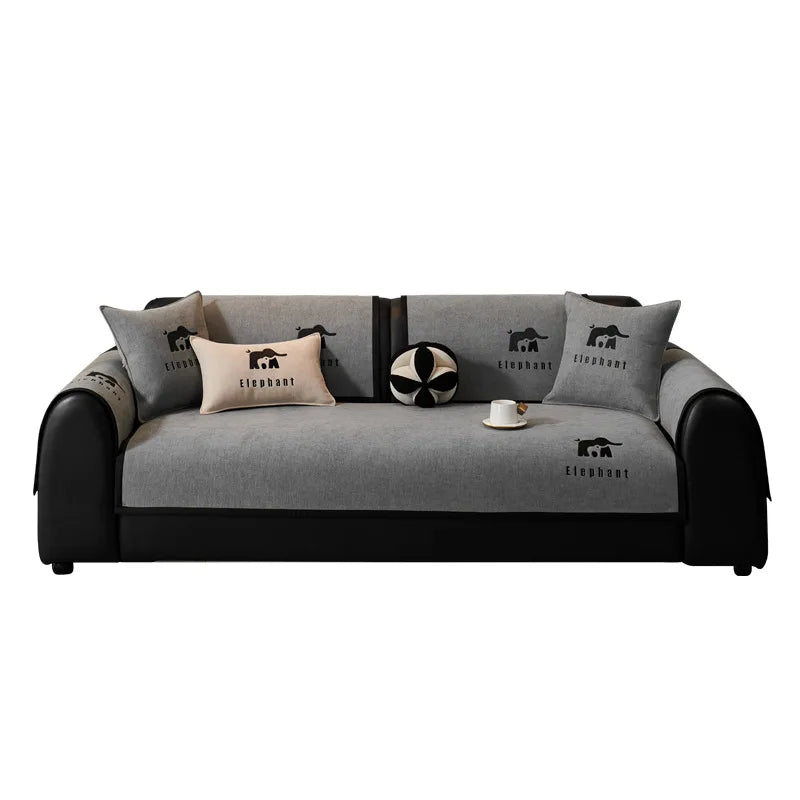 Canapé confortable en gris et noir avec des motifs d'éléphants, agrémenté de coussins décoratifs.