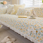 Un lit douillet et confortable décoré de coussins floraux dans des tons de jaune et de blanc, évoquant un lieu accueillant et serein.