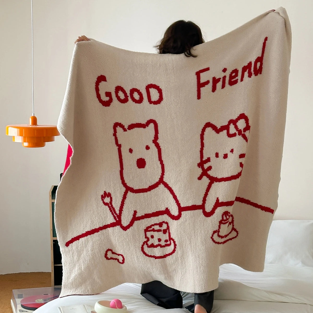 Une couverture douce et moelleuse avec de mignons dessins de personnages et le texte "Good Friend" écrit en rouge.