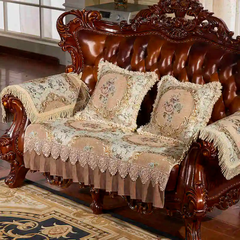 Un canapé en bois sculpté richement orné, avec des coussins en tissu fleuri décoré de dentelle, créant un style élégant et vintage dans cette pièce.