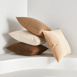 Des coussins décoratifs moelleux et confortables de différentes teintes sont empilés les uns sur les autres, offrant un aspect sophistiqué et relaxant à l'espace.