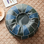 Pouf marocain en simili cuir PU de couleur gris clair, forme ronde, sur un sol en bois