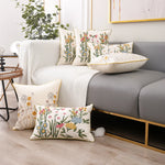 Cette chambre confortable est décorée avec des coussins décoratifs aux motifs floraux colorés et une couverture en tricot, créant une atmosphère chaleureuse et accueillante.